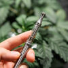 a hand holding metal dab pen