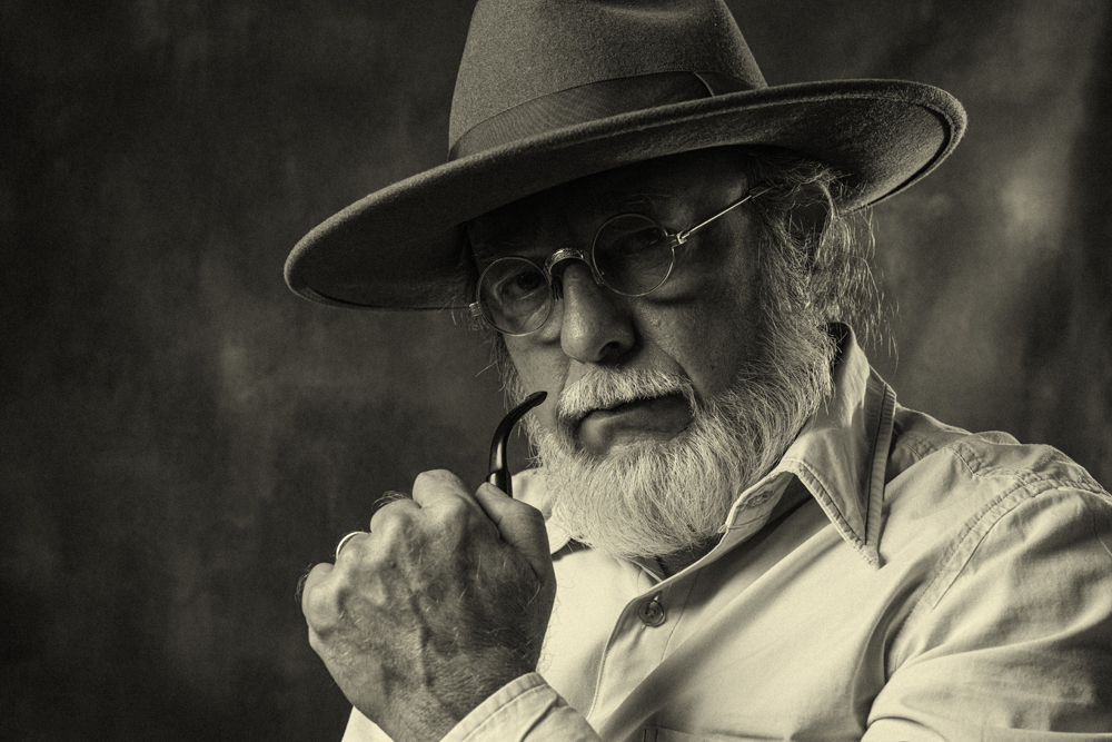 an old man holding smoke pipe